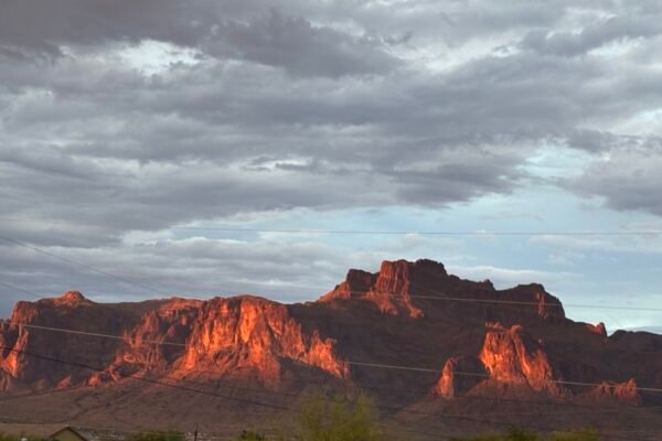 The Superstition Mountains glowing at sunset under storm clouds, Apache Junction
