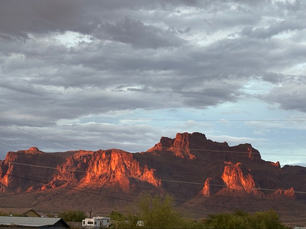 The Superstition Mountains glowing at sunset under storm clouds, Apache Junction