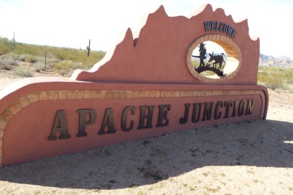 Welcome to Apache Junction road sign with prospector and burro cutout